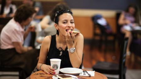 Una mujer, comiendo una cafetería