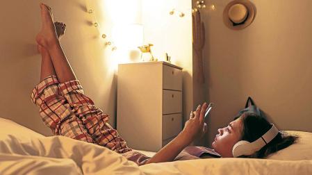 Un joven con auriculares mientras se entretiene con un videojuego