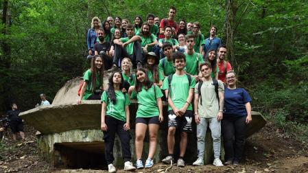 Los jóvenes participantes en el campo de voluntariado, junto a las autoridades que han visitado la zona