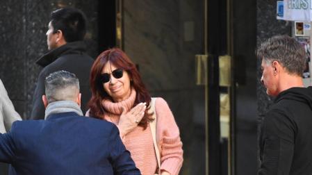 La vicepresidenta de Argentina, Cristina Fernández de Kirchner, saluda a sus simpatizantes mientras sale de su residencia custodiada por un dispositivo de seguridad