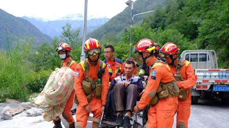 Operarios de rescate chino trasportan a uno de los heridos