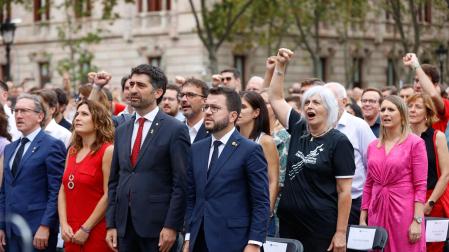 El presidente de la Generalitat, Pere Aragonès (c), junto a Jordi Puigneró (3i), Laura Vilagrá (2i), Jaume Giró (i), y su esposa Janina Juli (d), durante el acto organizado por Òmnium Cultural con motivo de la Diada del 11 de septiembre, este domingo en Barcelona