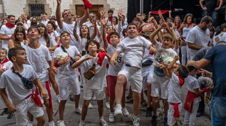 Los más jóvenes de Cirauqui saltaron para recoger los balones y caramelos que cayeron del balcón tras el cohete
