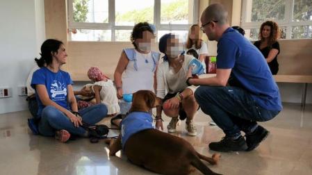 Miembros de la asociación Perruneando con un perro y niños en un hospital