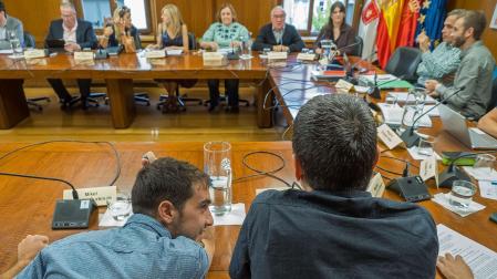 Los corporativos charlan -ediles de Bildu en primer término y de NA+ al fondo- minutos antes del inicio de la sesión plenaria