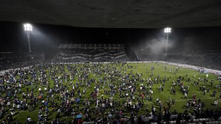 Espectadores en el terreno de juego tras ser suspendido el partido