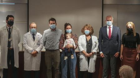 La pequeña Emma, de 13 meses, en brazos de su madre, Ana, acompañadas de su padre, Daniel, y las personas que han participado en el trasplante