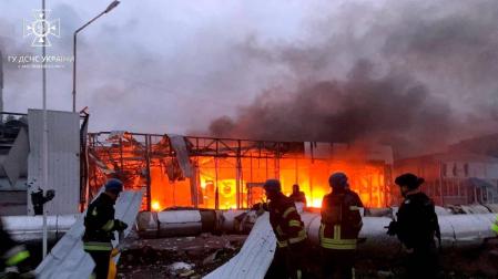 Los bomberos ucranianos trabajan en la extinción de un incendio en un concesionario de coches destruido por los bombardeos en Zaporiyia