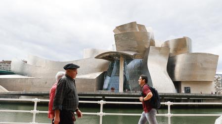 Varias personas pasan ante el Museo Guggenheim de Bilbao, obra del arquitecto Frank Gehry, que este año conmemora su 25 aniversario
