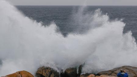 Un turista fotografía las olas en Muxía (Galicia)