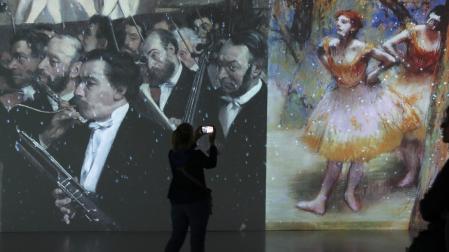 Pantallas gigantes proyectan imágenes en movimiento de las obras, como estas de Degas