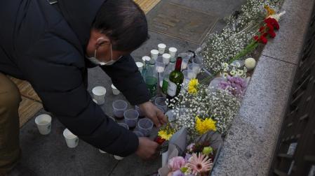 Un hombre deposita flores en el lugar de la tragedia