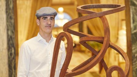 El artista guipuzcoano Íñigo Manterola, junto a una de sus esculturas abstractas en la que evoca el movimiento.