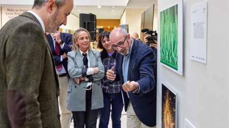 Ignacio López-Goñi, director del Museo de Ciencias de la UN, comenta las fotografías de Fotciencia ante el concejal Fermín  Alonso, la directora de Comunicación Científica de la UN, Elisa Montserrat y la directora de la Cátedra Mujer, Ciencia y Tecnología de la UPNA
