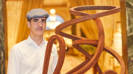 El artista guipuzcoano, junto a una de sus esculturas abstractas en la que evoca el movimiento