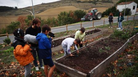 Ismael Sánchez Padilla (con el micro) y Marcelo Garísoain Guindano (con la cámara) graban el jueves en la huerta del colegio público de Urroz-Villa a sus compañeros Izan Ardanaz Alcaiza e Íñigo Saragüeta Arjona ante Patxi Burillo