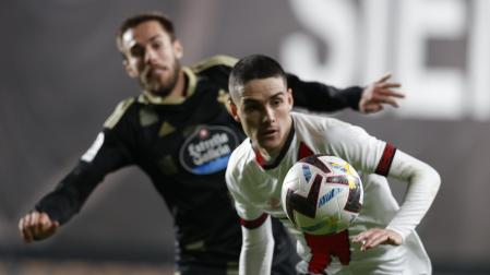 El delantero del Rayo Vallecano, Sergio Camello, con el balón ante el defensa del Celta, Óscar Mingueza