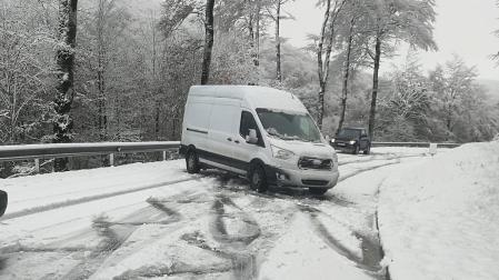 Una furgoneta cruzada en la carretera al puerto de Ibañeta por la presencia de nieve en la carretera