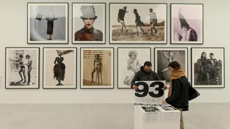 Dos personas observan las obras en la exposición `Steven Meisel 1993 A Year in Photographs¿ en el Muelle de la Batería de A Coruña, a 18 de noviembre de 2022, en A Coruña