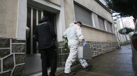 Dos agentes de Policía Nacional en la puerta de la vivienda donde ha sido hallada muerta una mujer de 42 años