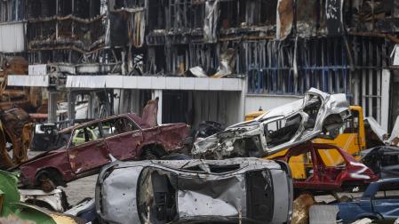 Vehículos destrozados apilados cerca de un centro comercial destruido durante un combate en Mariupol