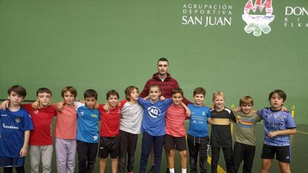 Una docena de pelotaris de la escuela de pelota a mano posan junto al técnico del club Iker Fernández.