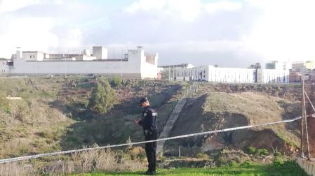 Un agente de la Policía, en la zona donde se ha hallado el cadáver de un niño de ocho años que había desaparecido en un barrio de Ceuta