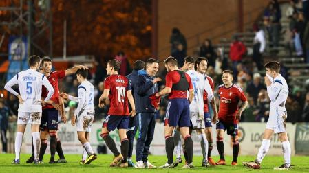Jugadores de Osasuna y Arnedo conversan sobre el terreno de juego tras finalizar el encuentro.