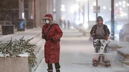 Dos personas, en las calles de Chicago, azotada por el temporal Elliot