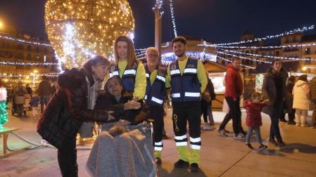 EN LA PLAZA DEL CASTILLO Pilar, junto a una de sus hijas y voluntarios de DYA Navarra, viendo las luces de Navidad en la plaza del Castillo