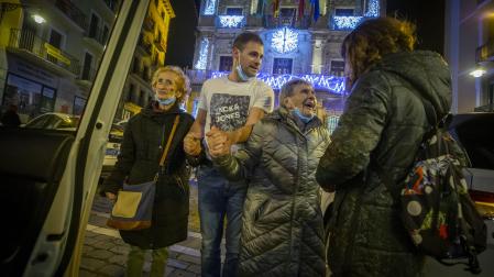 Pilar Iglesias (segunda por la derecha), de 100 años, sonríe tras visitar el belén del zaguán del Ayuntamiento de Pamplona