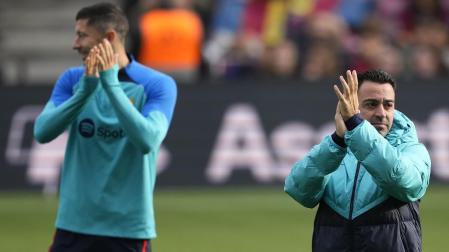 Xavi Hernández (dcha.) y el delantero polaco Robert Lewandowski (izda.), saludan a los seguidores azulgranas que se dieron cita en el Spotify Camp Nou para seguir en directo el entrenamiento de la plantilla del FC Barcelona.