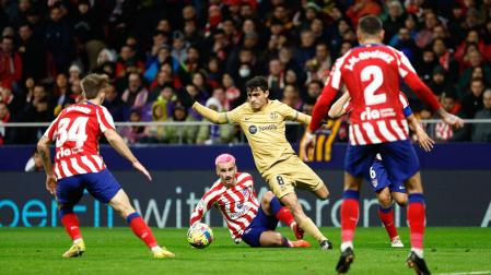 El centrocampista del FC Barcelona, Pedri, se lleva el balón ante el delantero francés del Atlético de Madrid, Antoine Griezmann