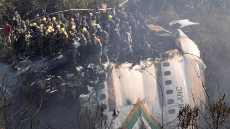 Equipos de rescate tratan de buscar supervivientes entre los restos del avión accidentado en Nepal