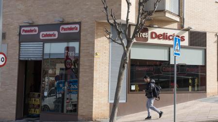 Un joven camina ante la cafetería Tres Delicias, donde se produjeron los hechos