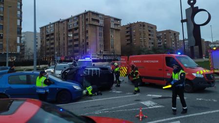 Bomberos de Navarra trabajan junto al automóvil accidentado.