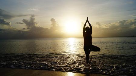 Una persona hace yoga en la plaza al amanecer.