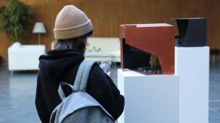 Una persona contempla una de las doce esculturas de la exposición instalada en el Parlamento, unas piezas inspiradas en la serie Cajas vacías de Jorge Oteiza