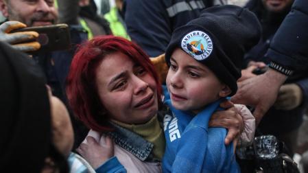 Un niño, junto a su madre, tras ser rescatado de los escombros en Turquía
