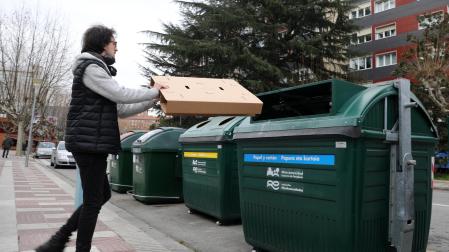 Una persona se dispone a introducir una caja de cartón en el contenedor.