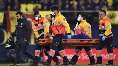 Los camilleros y un médico del Villarreal acompañan a Francis Coquelin cuando es retirado tras su lesión.