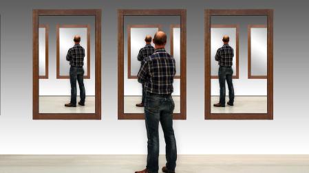 Un hombre observa su imagen repetida en varios espejos