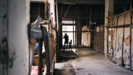 Un joven cubano y un niño juegan en el pasillo de un edificio abandonado - La Habana, Cuba, diciembre de 2022.