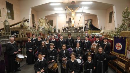 La nueva banda de tambores de la Hermandad, poco antes del traslado. Tras ellos, el paso del Cristo Alzado en la casa de Dormitalería, edificio obra del arquitecto Víctor Eusa, con la singular cubierta de arcos de hormigón, que dotan de suficiente altura.