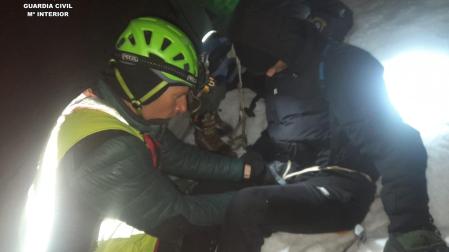 Un agente de la Guardia Civil asegura a uno de los jóvenes durante el rescate
