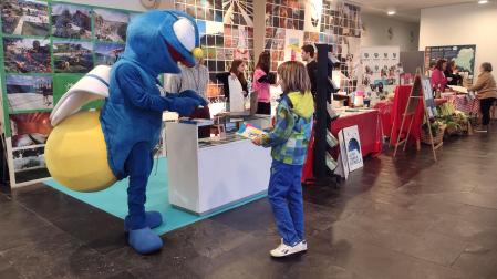 La mascota de Campings Navarra, Argi, en un expositor de Navartur