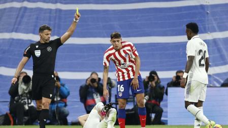 Gil Manzano muestra tarjeta amarilla al argentino Nahuel Molina (Atlético de Madrid) en el derbi ante el Real Madrid