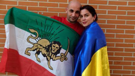 Elena y Sami, con las banderas de sus países, Ucraniana e Irán, en el barrio pamplonés de la Rochapea