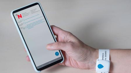 Imagen de la pulsera de geolocalización para el paciente y de la aplicación “Virtual Waiting Room” para el teléfono del acompañante