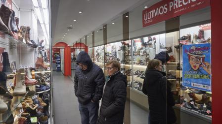 Dos personas observan las ofertas de una zapatería en el Casco Antiguo pamplonés